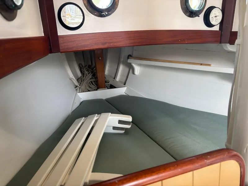 Slide: The Image of Interior of a 1951 Custom Pilot Cutter, featuring cozy sleeping quarters and nautical decor. - 11