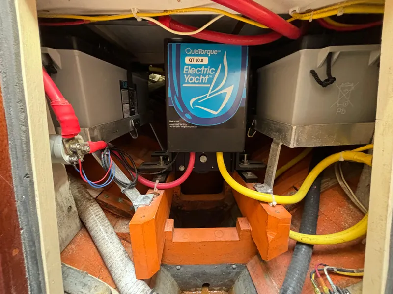 Slide: The Image of Electric yacht motor installation in a 1951 Custom Pilot Cutter, featuring colorful wiring and battery setup. - 17