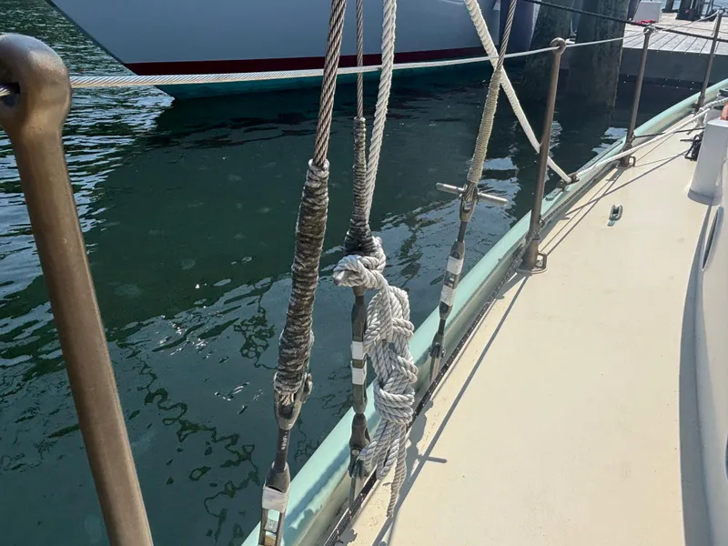 Slide: The Image of Rope rigging on a 1951 Custom Pilot Cutter, docked by the water. - 24