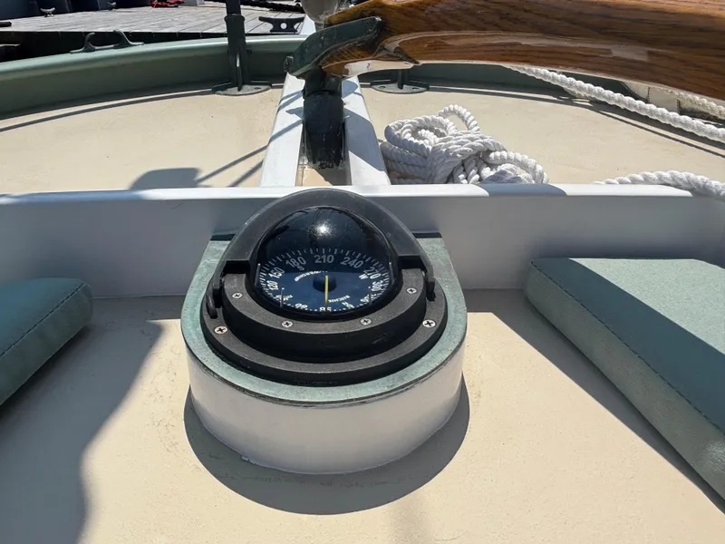 Slide: The Image of Compass on 1951 Custom Pilot Cutter deck, with ropes and wooden tiller visible. - 26