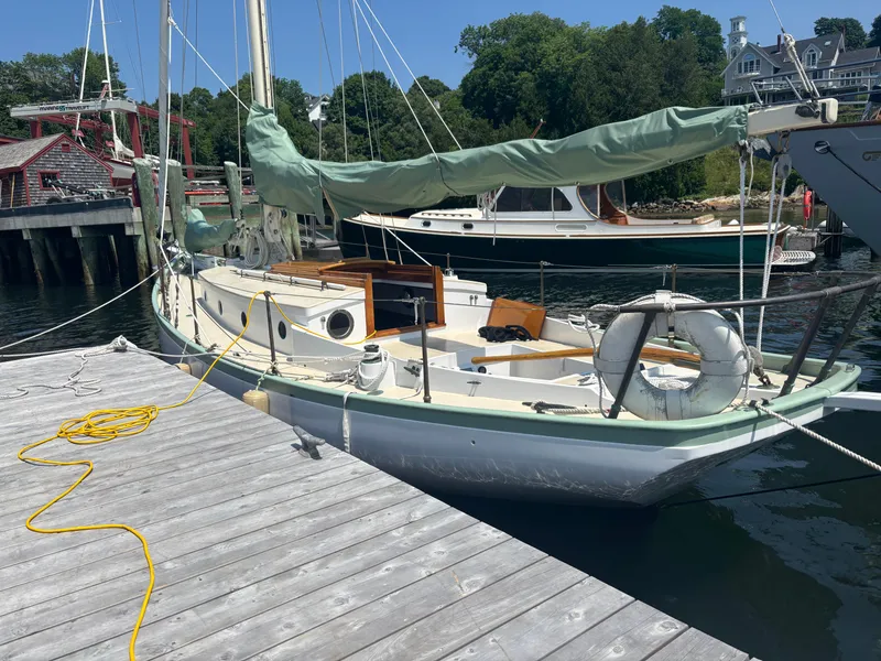 Slide: The Image of 1951 Custom Pilot Cutter docked at a wooden pier, surrounded by calm water and greenery. - 3