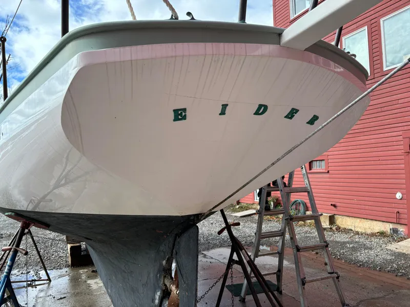 Slide: The Image of Custom 1951 Pilot Cutter "Eider" on dry dock near red building. - 30