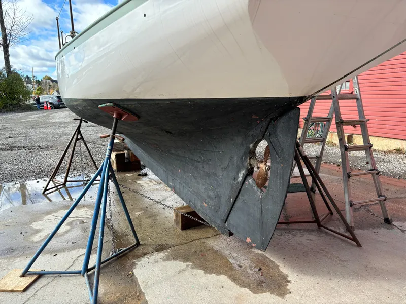 Slide: The Image of 1951 Custom Pilot Cutter on stands, hull and propeller visible, outdoor setting. - 31