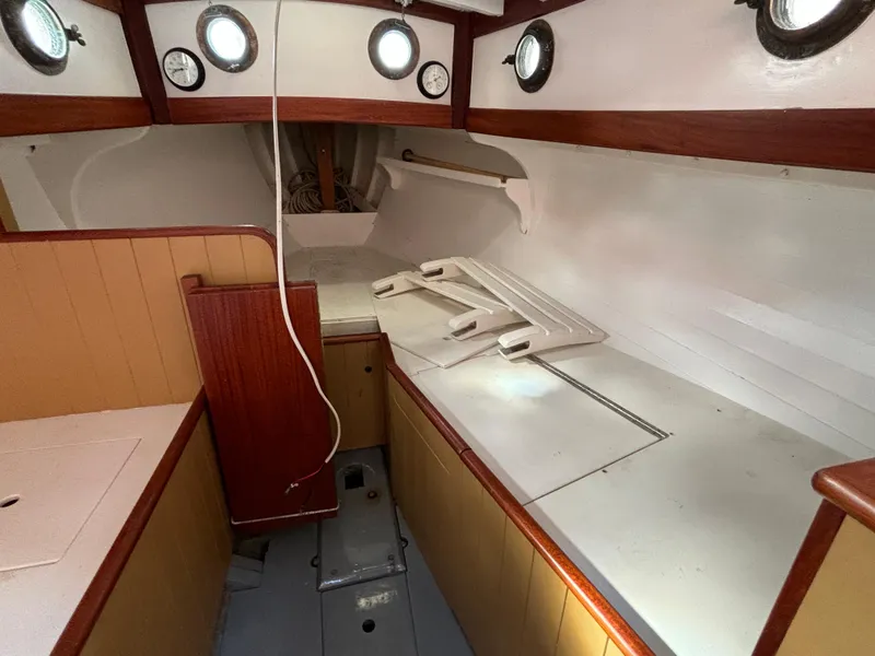 Slide: The Image of Interior of a 1951 Custom Pilot Cutter, featuring wooden accents and portholes. - 34