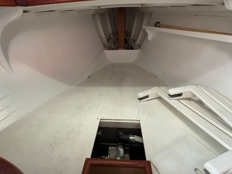 Slide: The Image of Interior of a 1951 Custom Pilot Cutter, showcasing white wooden flooring and storage space. - 35
