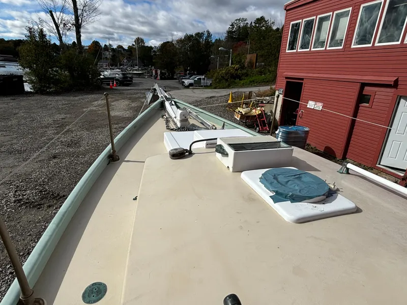 Slide: The Image of 1951 Custom Pilot Cutter on land, near red building, under cloudy sky. - 39