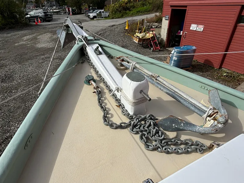 Slide: The Image of 1951 Custom Pilot Cutter deck with anchor and chain, docked near red building. - 40
