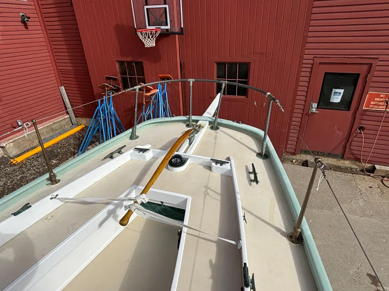 Slide: The Image of 1951 Custom Pilot Cutter boat deck near red building with basketball hoop. - 43