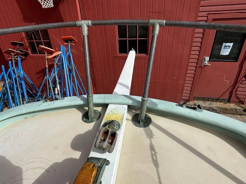 Slide: The Image of 1951 Custom Pilot Cutter deck with railing, docked near red building. - 44