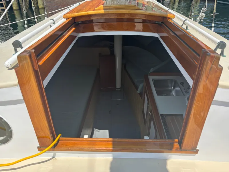Slide: The Image of Interior view of a 1951 Custom Pilot Cutter, featuring a compact cabin and kitchenette. - 8