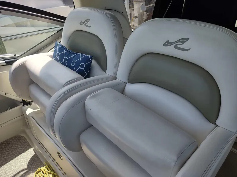 Slide: The Image of 2007 Sea Ray 340 Sundancer interior with curved seating and wooden table. - 12