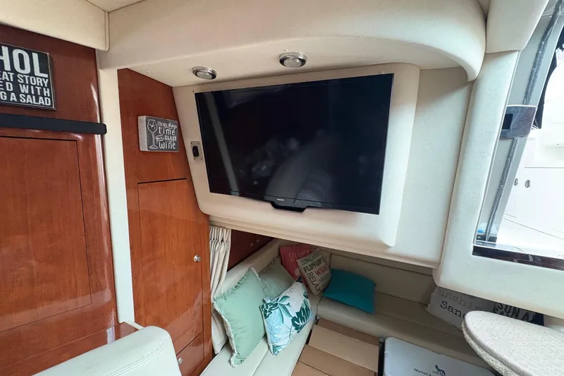 Slide: The Image of Interior of 2007 Sea Ray 340 Sundancer with TV, cushions, and wooden cabinetry. - 21