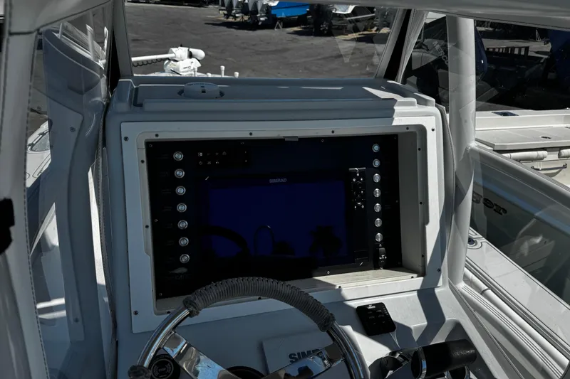 Slide: The Image of 2019 Dorado 25 Flat Deck boat dashboard with navigation controls and steering wheel. - 17