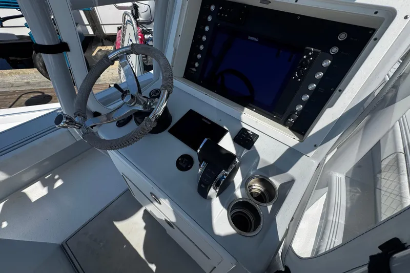 Slide: The Image of 2019 Dorado 25 Flat Deck boat helm with steering wheel and control panel. - 18