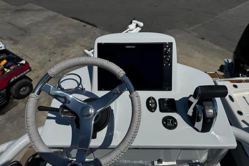 Slide: The Image of 2019 Dorado 25 Flat Deck boat helm with steering wheel and navigation controls. - 24