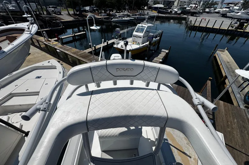 Slide: The Image of 2019 Dorado 25 Flat Deck boat docked at marina, featuring white quilted seating. - 25