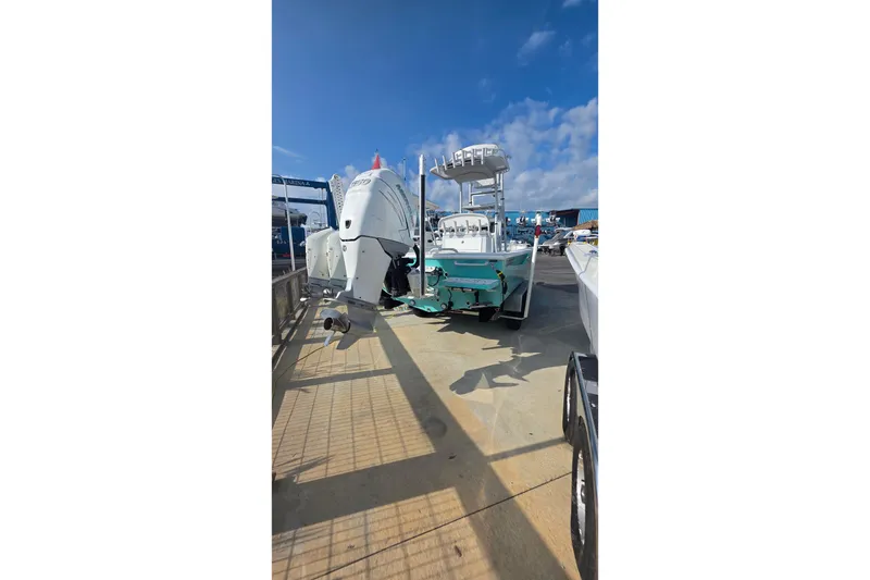 Slide: The Image of 2019 Dorado 25 Flat Deck boat with dual engines at a marina under a clear blue sky. - 30