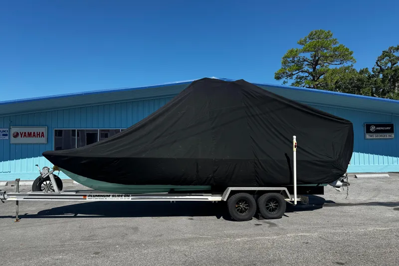 Slide: The Image of 2019 Dorado 25 Flat Deck boat covered on trailer, parked outside dealership. - 35