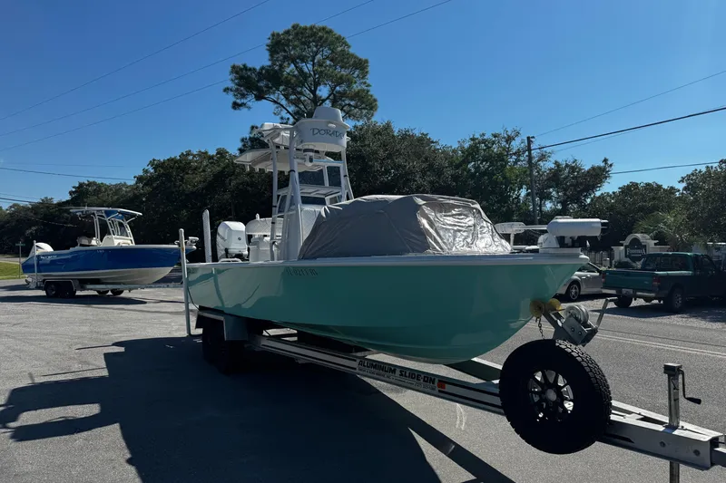 Slide: The Image of 2019 Dorado 25 Flat Deck boat on trailer, parked outdoors under clear blue sky. - 7