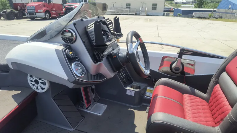 Slide: The Image of 2021 Vexus VX20 boat interior with steering wheel, dashboard, and red-accented seating. - 10