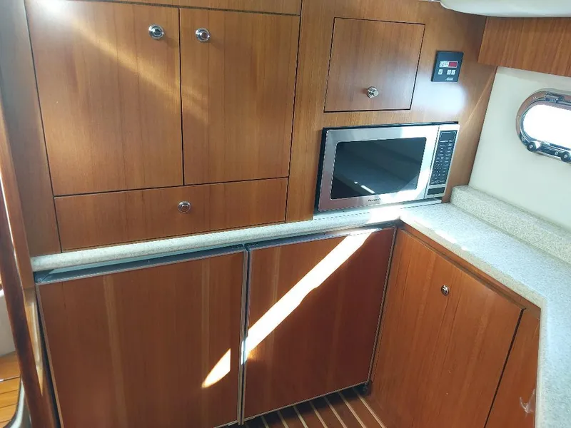 Slide: The Image of 2003 Tiara Yachts 4400 Sovran kitchen with wood cabinets and built-in microwave. - 12