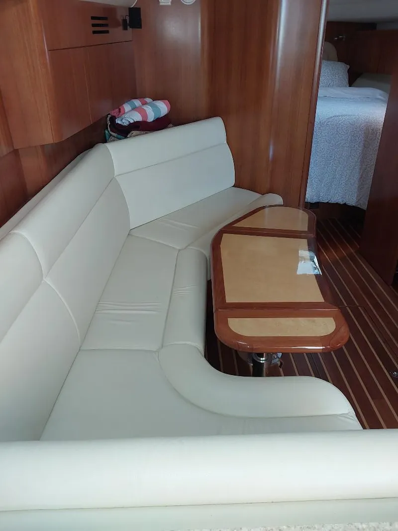 Slide: The Image of Interior of 2003 Tiara Yachts 4400 Sovran with cream seating and wooden table. - 14