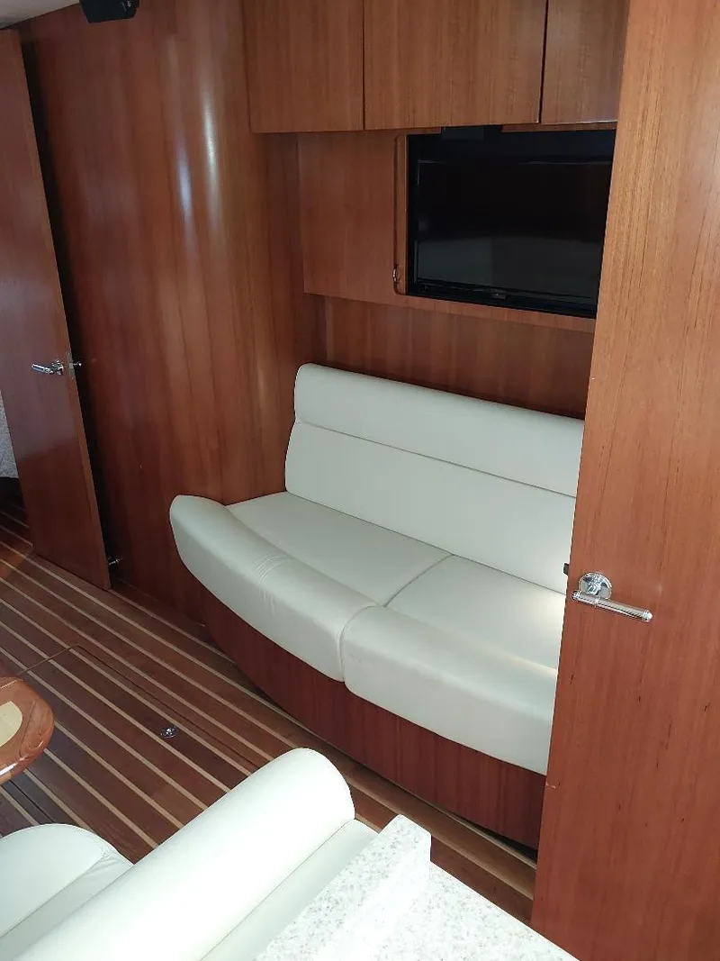 Slide: The Image of Interior of 2003 Tiara Yachts 4400 Sovran with white seating and wood paneling. - 15