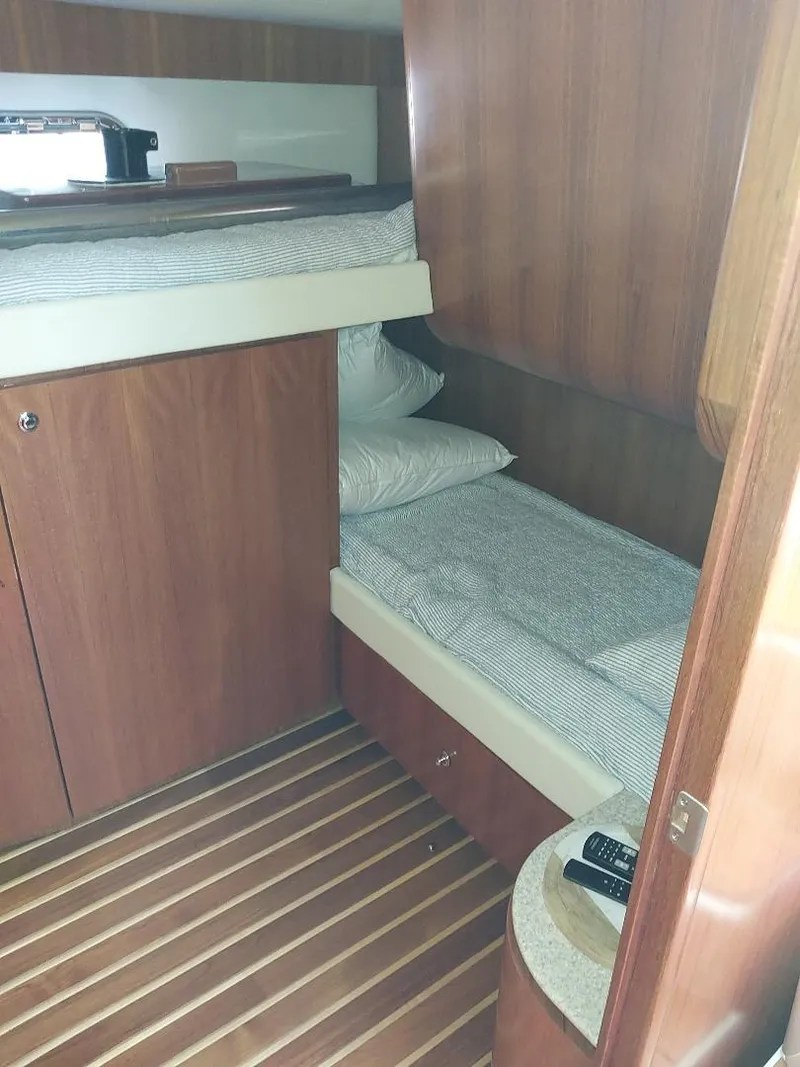 Slide: The Image of 2003 Tiara Yachts 4400 Sovran cabin with wooden interior and bunk beds. - 18