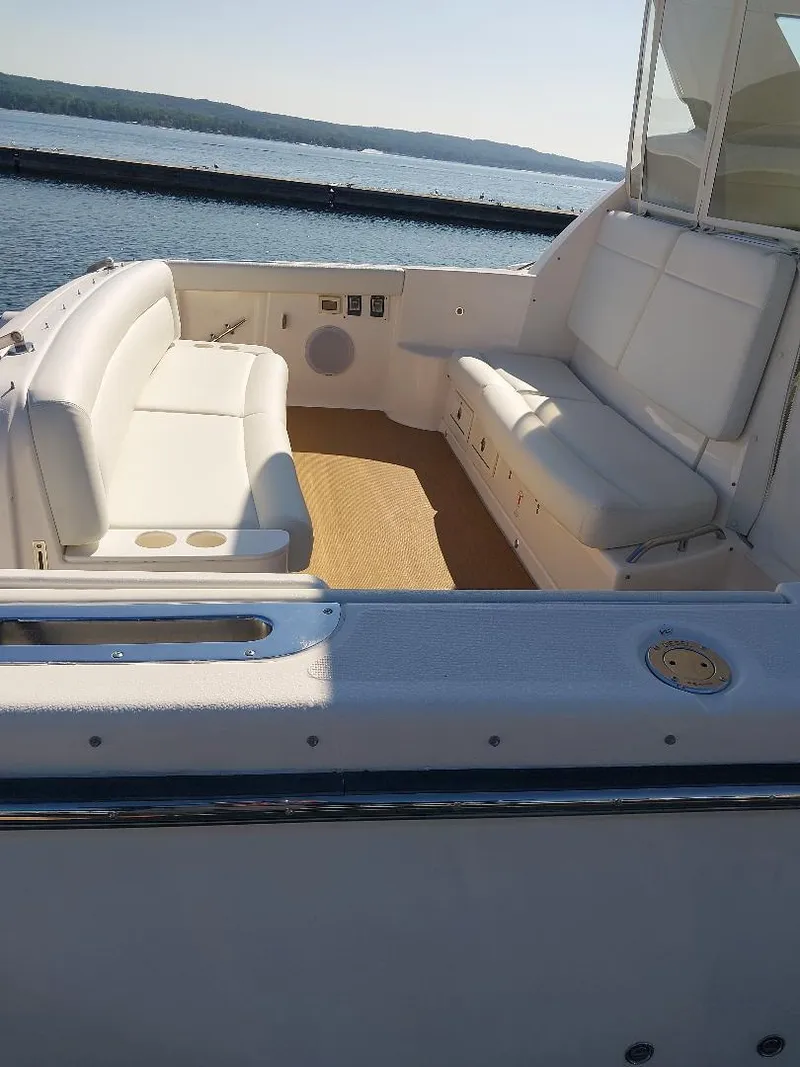Slide: The Image of 2003 Tiara Yachts 4400 Sovran cockpit with white seating, overlooking calm waters. - 6