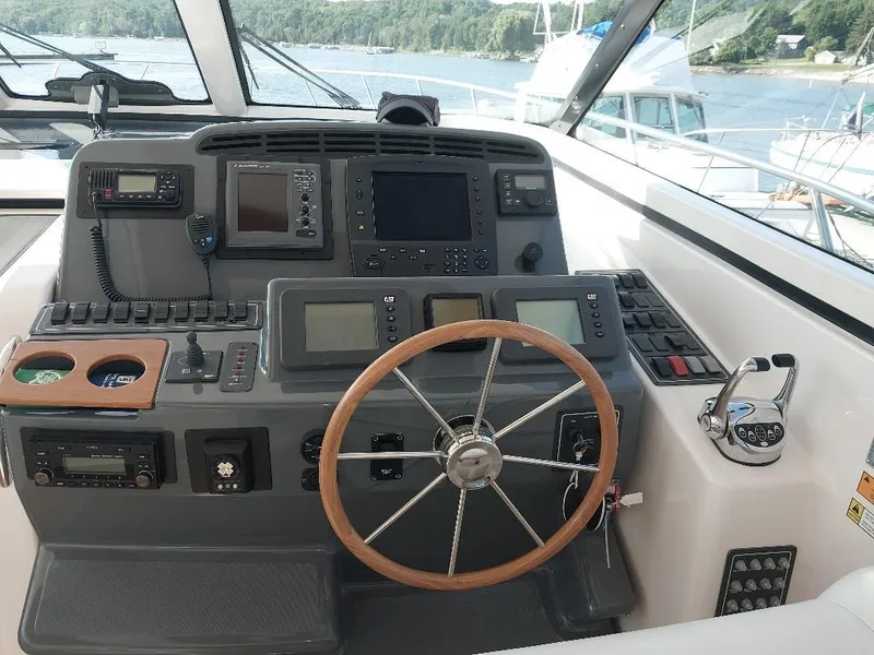 Slide: The Image of Helm of 2003 Tiara Yachts 4400 Sovran with navigation equipment and wooden steering wheel. - 7
