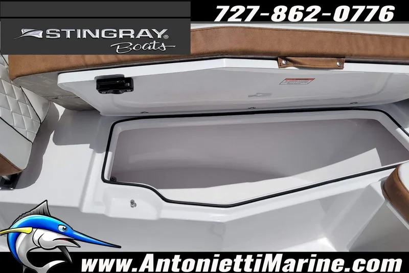 Slide: The Image of 2026 Stingray 253 CC boat storage compartment, featuring brown seating and marine branding. - 20