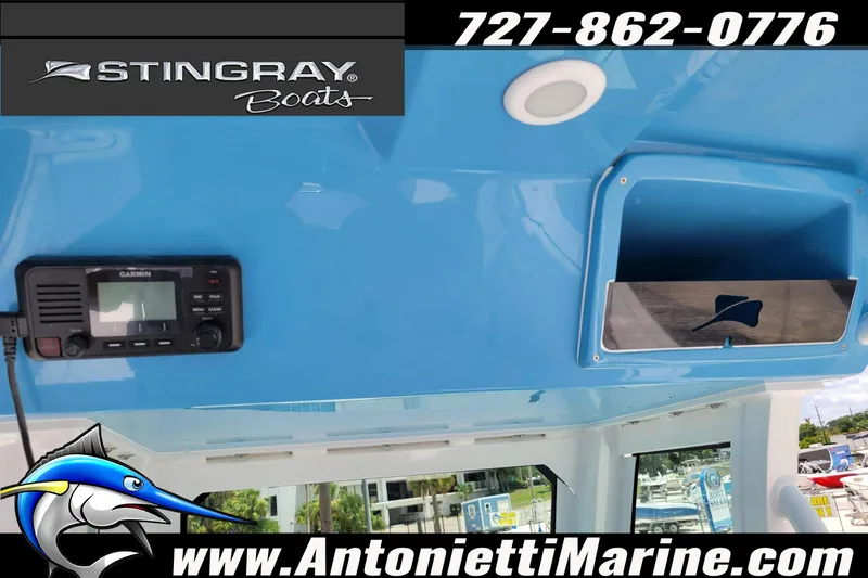 Slide: The Image of 2026 Stingray 253 CC boat interior with Garmin device, blue dashboard, and storage compartment. - 25
