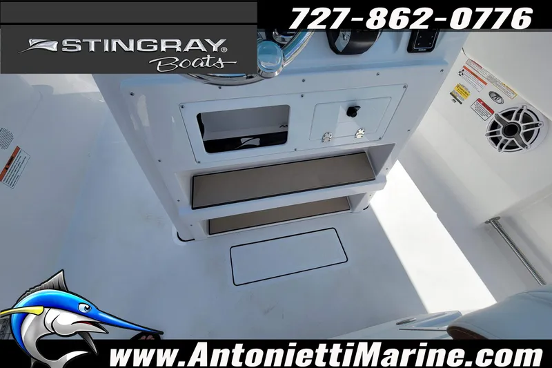Slide: The Image of 2026 Stingray 253 CC boat interior with console, speaker, and storage compartments. - 28
