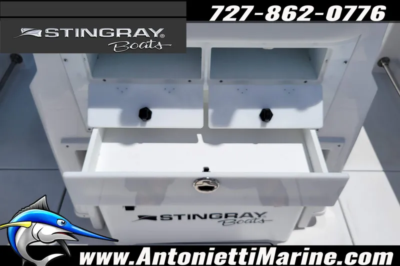 Slide: The Image of 2026 Stingray 253 CC boat storage compartments with branding and contact information. - 56