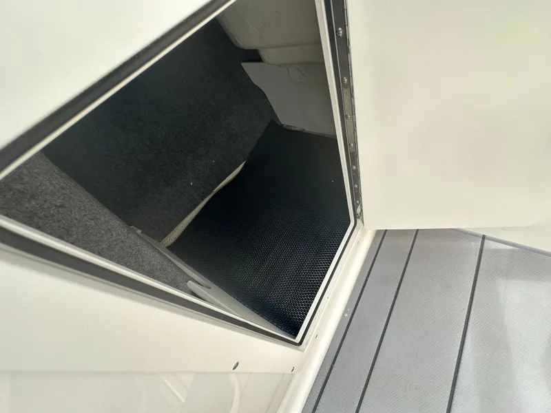 Slide: The Image of 2023 Chaparral 21 SSi OB boat storage compartment with carpeted interior. - 14