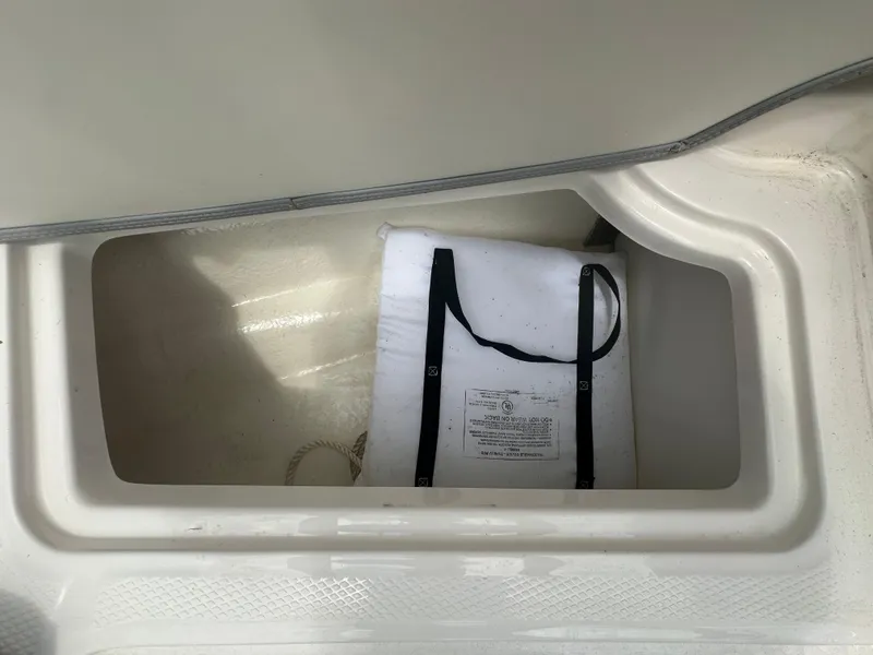 Slide: The Image of Storage compartment in 2023 Chaparral 21 SSi OB boat with life jacket inside. - 18
