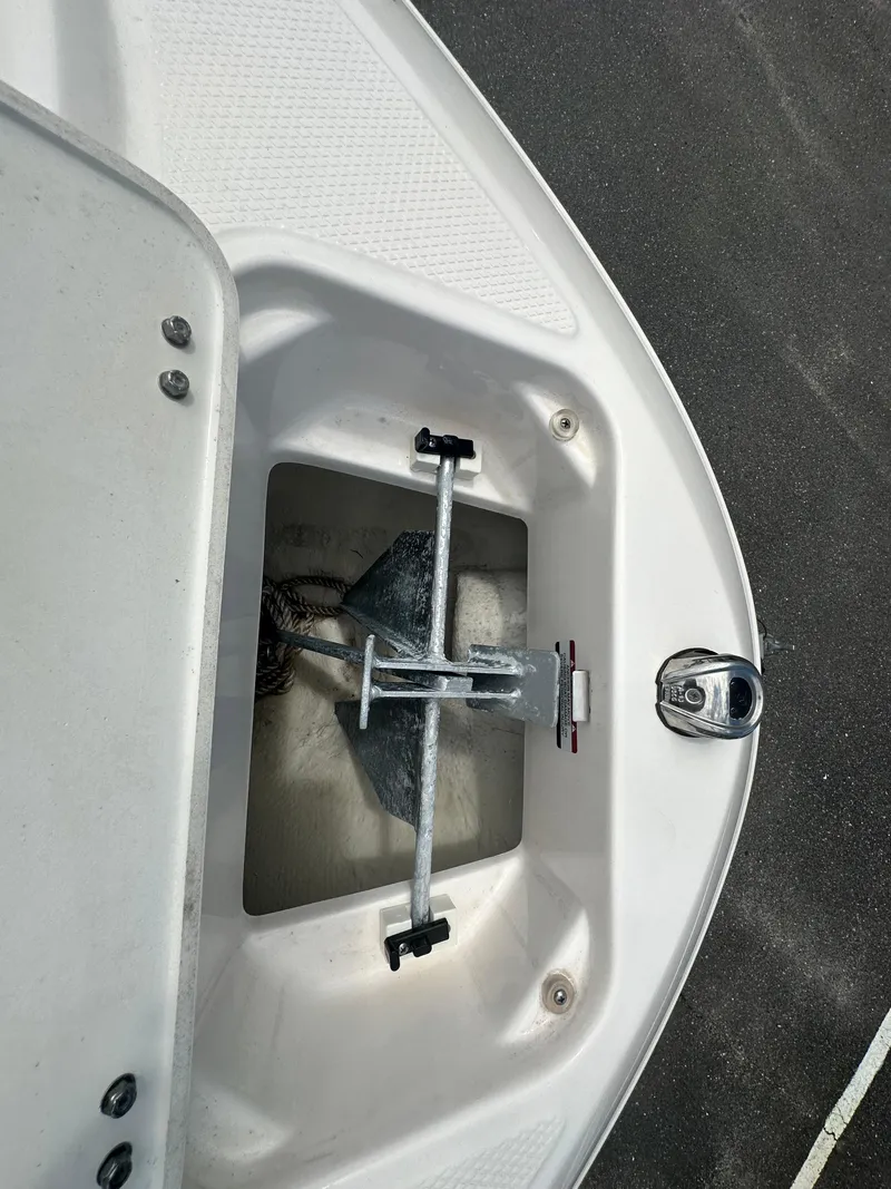 Slide: The Image of 2023 Chaparral 21 SSi OB boat anchor compartment with secured anchor and rope. - 19