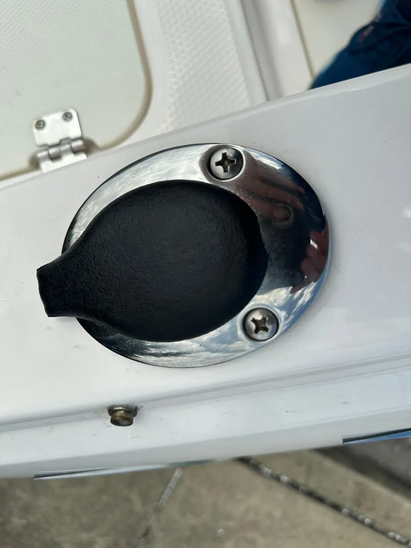 Slide: The Image of Fuel cap on 2023 Chaparral 21 SSi OB boat, featuring chrome finish and secure screws. - 23