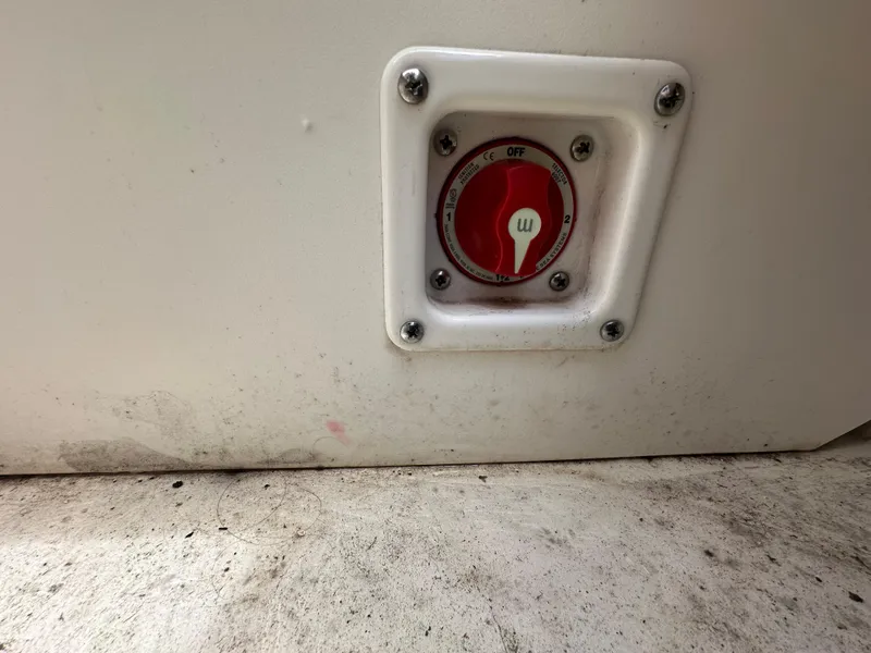 Slide: The Image of Battery switch on 2023 Chaparral 21 SSi OB boat, mounted on a white panel. - 27