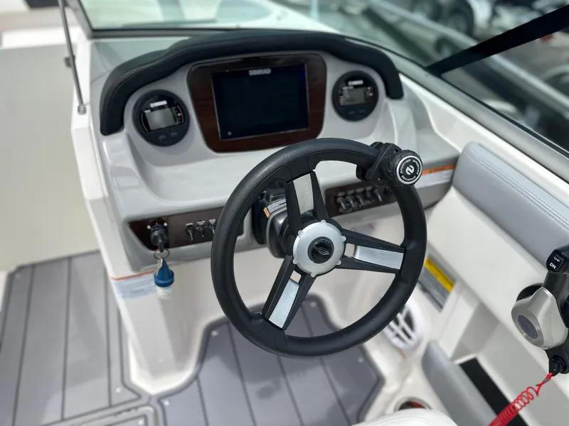 Slide: The Image of 2023 Chaparral 21 SSi OB boat dashboard with steering wheel and controls. - 28
