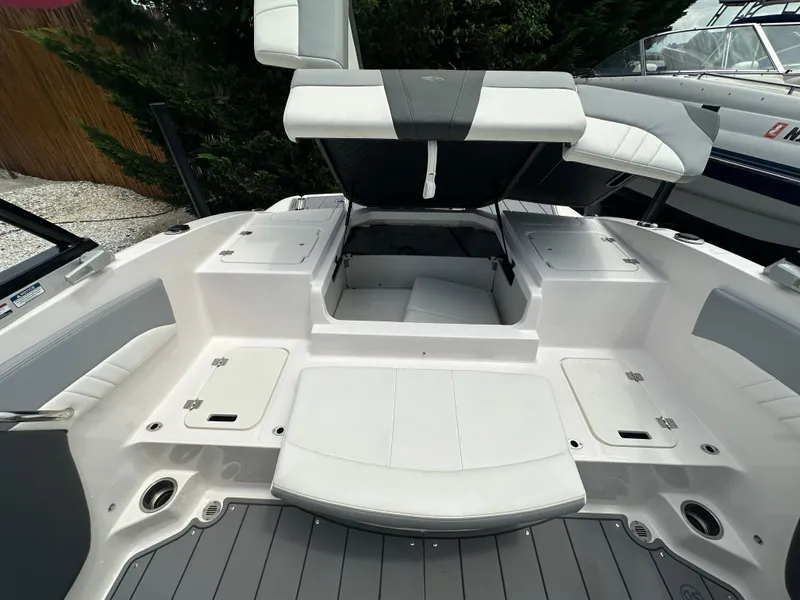 Slide: The Image of 2023 Chaparral 21 SSi OB boat interior with open storage compartments and seating. - 9