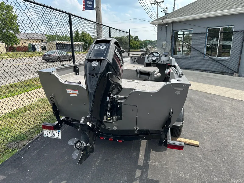 Slide: The Image of 2017 Crestliner 1600 Vision boat with Mercury 60 outboard motor, parked on pavement. - 2