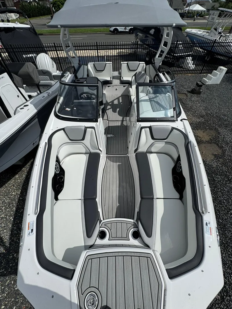 Slide: The Image of 2023 Yamaha Boats 252SD with sleek interior and modern design, docked outdoors. - 14