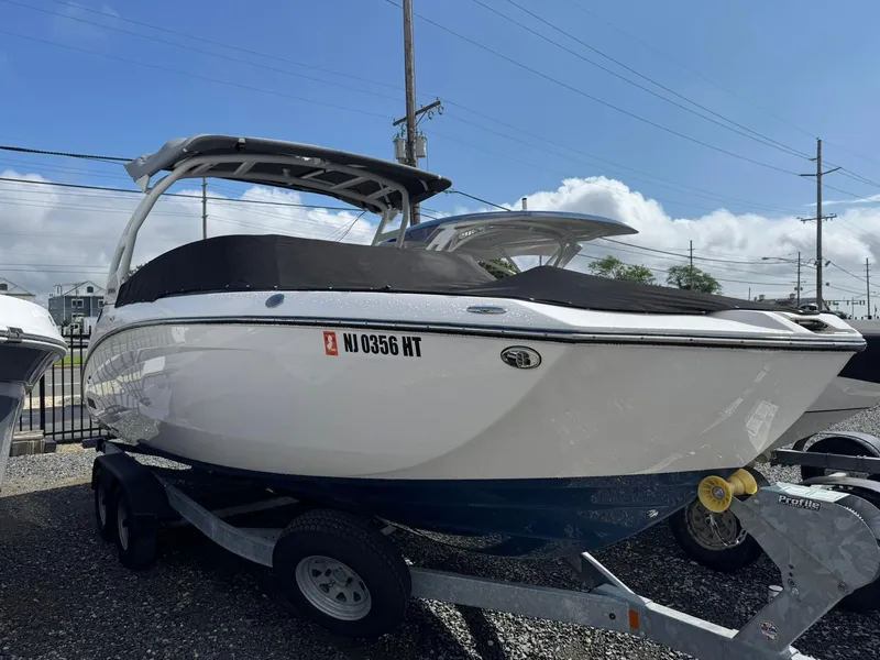 Slide: The Image of 2023 Yamaha Boats 252SD on trailer, sleek design, covered, parked outdoors. - 25