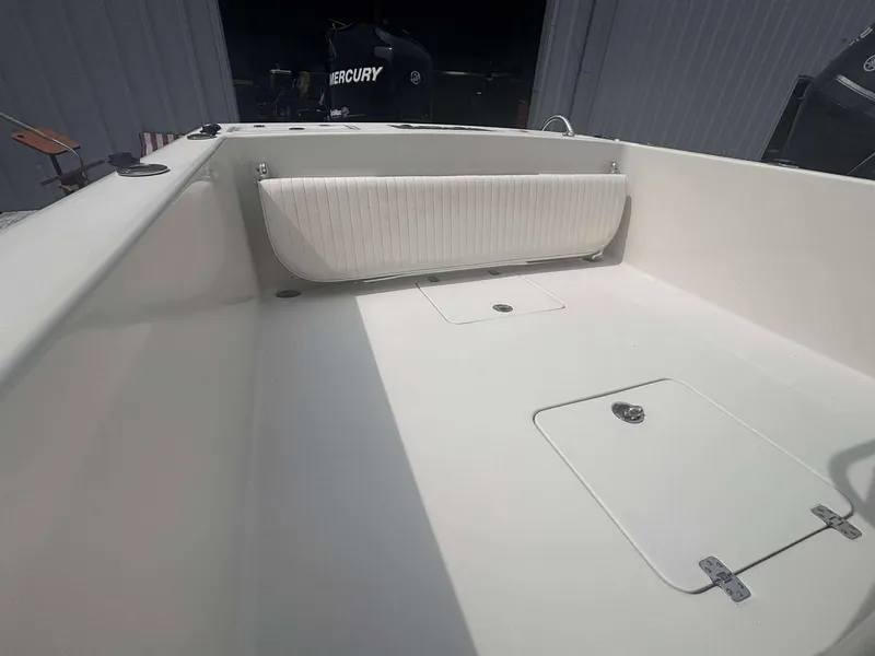 Slide: The Image of 2015 Andros Tarpon 26 boat interior with white seating and storage compartments. - 13