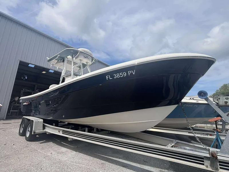 Slide: The Image of 2015 Andros Tarpon 26 boat on trailer, parked outside a warehouse. - 2