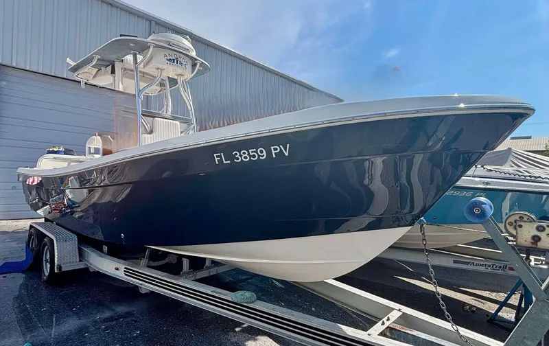 Slide: The Image of 2015 Andros Tarpon 26 boat on trailer, parked outside a warehouse. - 18
