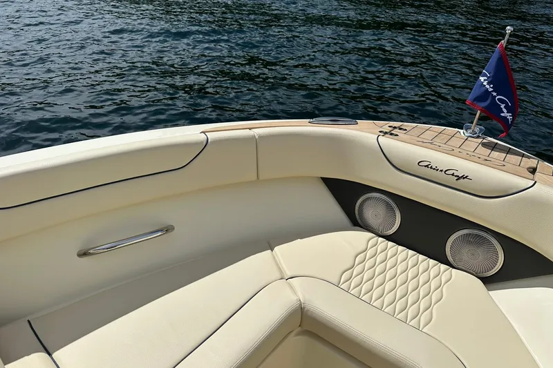 Slide: The Image of 2026 Chris-Craft Sportster 25 boat interior with elegant seating and branded flag on water. - 14