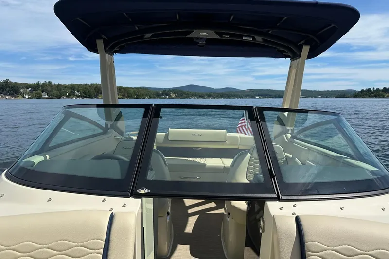 Slide: The Image of 2026 Chris-Craft Sportster 25 boat on a serene lake with scenic mountain backdrop. - 17