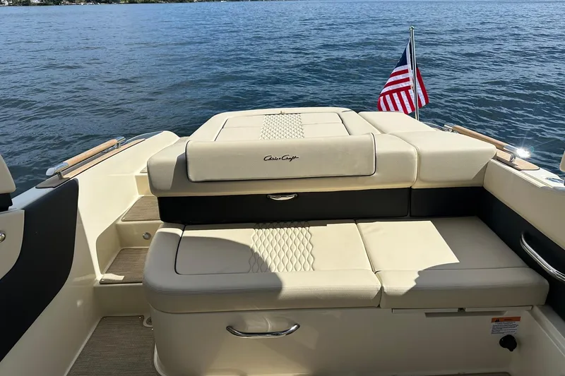 Slide: The Image of 2026 Chris-Craft Sportster 25 boat interior with American flag on a lake. - 21